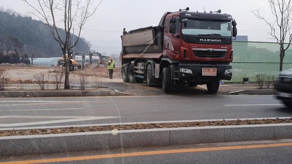 세륜 세척을 안하고 토사매립현장을 나오고 있는 덤프트럭,신호수가 없어서 일반차량들이 사고 위험에 무방비 상태로 노출되어있는 모습.(사진=이영진 기자)